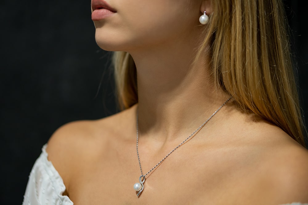 Model trägt silberne Damenhalskette mit einer weißen Perle